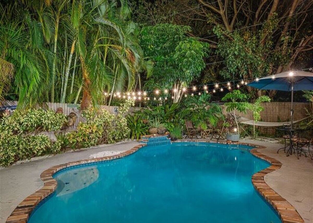 Pool lit by string lights at night.